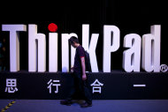 A man walks past a ThinkPad logo during a promotional event for the new Thinkpad X1 Carbon laptop in Beijing Monday, Aug. 6, 2012. The Chinese computer maker unveiled the lighter, quicker ThinkPad notebook computer inspired by the convenience of tablets and smart phones. (AP Photo/Alexander F. Yuan)