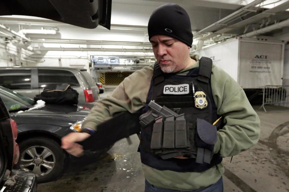 In this March 2, 2015 photo, an Immigration and Customs Enforcement officer "tacs up" in the garage of a New York federal building, as he...