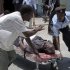 Somalis stretcher away a man wounded in a blast at the Somali National Theater in Mogadishu, Somalia Wednesday, April 4, 2012. A suicide blast during a ceremony at Somalia's newly reopened national theater on Wednesday killed at least 10 people, including two of the country's top sports officials, officials said. (AP Photo/Mohamed Sheikh Nor)