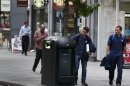 A youth uses a trash bin in central London, Monday, Aug. 12, 2013. Officials say that an advertising firm must immediately stop using its network of high-tech trash cans, like this one, to track people walking through London's financial district. The City of London Corporation says it has demanded Renew pull the plug on the program, which measures the Wi-Fi signals emitted by smartphones to follow commuters as they pass the garbage cans. (AP Photo/Lefteris Pitarakis)