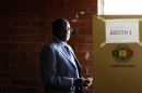 Zimbabwe's President Mugabe looks on before casting his vote in Highfields