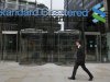 FILE - In this Aug. 7, 2012 file photo, a man walks past the headquarters of Standard Chartered bank in London. Benjamin Lawsky, New York's superintendent of financial services, said Tuesday, Aug. 14, 2012, that his agency has reached a $340 million settlement with Standard Chartered Bank to resolve an investigation into whether the British bank schemed with the Iranian government to launder $250 billion from 2001 to 2007. (AP Photo/Sang Tan, File)