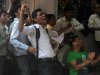 Indian fans celebrate as they watch Sachin Tendulkar score his 100th century on a television set inside a shop in Mumbai