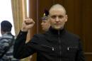 Russian opposition activist Sergei Udaltsov gestures in a court room during a trial in Moscow, Russia, Thursday, July 24, 2014. Russian news agencies say two opposition activists, Sergei Udaltsov and Leonid Razvozzhayev, have been convicted of organizing riots at the May 2012 protest in Moscow, a day before the inauguration of President Vladimir Putin. (AP Photo/Ivan Sekretarev)