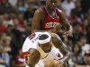 Miami Heat forward LeBron James, foreground, attempts to stay on his feet as he breaks for the basket trailed by Philadelphia 76ers forward Elton Brand during the first half of an NBA basketball game, Tuesday, April 3, 2012 in Miami. (AP Photo/Wilfredo Lee)