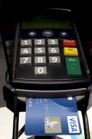 A credit card is seen inserted in a card reader at a store in Stockholm