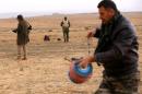 Kurdish peshmerga fighters work on detonating landmines planted by the Islamic State (IS) group fighters on the outskirts of the village of Sinoni in the northern Iraqi district of Sinjar on January 15, 2015