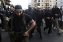 Armed supporters of Salafist leader al-Assir escort him during a funeral in Sidon