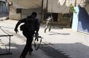 Members of the Free Syrian Army run to avoid a sniper during clashes with pro-government forces in Harem