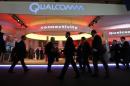 Visitors walk past the Qualcomm stand at the Mobile World Congress in Barcelona