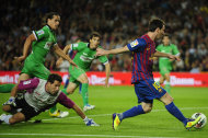 Lionel Messi se le escabulle a la defensa y al arquero para anotarle el Racing de Santander el sábado 15 de octubre del 2011 uno de sus dos goles que apoyaron el triunfo 3-0 del Barcelona en el Camp Nou. (Foto AP/Manu Fernández)