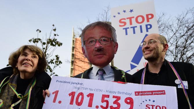 An activist wearing a mask of European Commission President Jean-Claude Juncker protests against the US-EU Transatlantic Trade and Investment Partnership (TTIP) in Brussels, on December 9, 2014