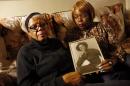 In this March 12, 2014 photo, Alma Murdough and her daughter Cheryl Warner hold a photo of Murdough's son, at her home in the Queens borough of New York. Jerome Murdough, a mentally ill, homeless former Marine arrested for sleeping in the roof landing of a New York City public housing project during one of the coldest recorded winters in city history, died last month in a Rikers Island jail cell that multiple city officials say was at least 100 degrees when his body was discovered. Murdough, 56, was found dead in his cell in a mental observation unit in the early hours of Feb. 15, after excessive heat, believed to be caused by an equipment malfunction, redirected it's flow to his upper-level cell, the officials said. (AP Photo/Jason DeCrow)