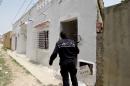 A Tunisian policeman stands guard outside a house where two suspected jihadists were killed in Mnihla, on May 11, 2016