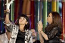 President Cristina Fernandez, right, applauds as Susana Trimarco, left, lifts a human rights prize given by the president during a rally to mark the 29th anniversary of the return to democracy in Argentina, on the eve of the Human Rights Day, in Buenos Aires, Argentina, Sunday, Dec. 9, 2012. Trimarco is known for her crusade to find her daughter, Maria de los Angeles "Marita" Veron, who disappeared in 2002, and who is believed to had been kidnapped by human traffickers. (AP Photo/Victor R. Caivano)