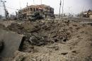 Iraqi counter-terrorism service vehicles drive past an explosion crater January 21, 2017 while patrolling the Andalus neighbourhood in the city of Mosul after government forces retook control of the area from the IS group