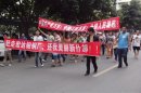 Local residents march with banners during a protest along a street in Shifang