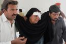 Residents help an injured Shiite relative following an attack in the south-west Pakistani town of Taftan, at a hospital in Quetta on June 9, 2014