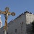 In this Friday, Dec. 24, 2010 file photo, a cross is seen backdropped by the Church of Nativity, traditionally believed by Christians to be the birthplace of Jesus Christ, during a Christmas parade in the West Bank town of Bethlehem. A long-needed renovation of the Church of the Nativity is slowly getting under way in Bethlehem, the town of Jesus' birth, in the face of political and religious conflicts that have kept one of Christendom's holiest sites in a state of decay for centuries. (AP Photo/Nasser Shiyoukhi, File)