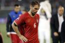 Serbia's Branislav Ivanovic bows his head while leaving the pitch during the Euro 2016 Group I qualifying match between Serbia and Albania at the Partizan stadium in Belgrade, Serbia, Tuesday, Oct. 14, 2014. The European Championship qualifier between Serbia and Albania was suspended on Tuesday after pitch skirmishes involving players and fans over an Albanian flag that was flown above the stadium by a drone. (AP Photo/Marko Drobnjakovic)