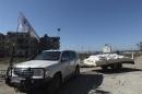 A U.N. vehicle towing a trailer with humanitarian aid arrives at a besieged area of Homs