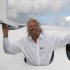 Sir Richard Branson poses for the photographers in the window of a replica of the Virgin Galactic, which according to the company will be the world’s first commercial spaceline, at the Farnborough International Airshow in Farnborough, England, Wednesday,  July 11, 2012. Branson also revealed a plan to launch small satellites into space at a tenth of the current cost. (AP Photo/Lefteris Pitarakis)