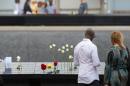 People look over the north memorial pool during the 15th anniversary of September 11 at the 9/11 Memorial and Museum, on September 11, 2016 in New York
