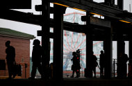 The Coney Island Wonder Wheel looms in the background as residents walks along the platform to catch one of the few remaining subway trains for the day while evacuating before the arrival of Hurricane Irene Saturday, Aug. 27, 2011 in Coney Island section of New York. (AP Photo/Craig Ruttle)