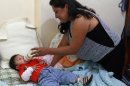 In this May 19, 2013 photo, Ruth Gonzalez, a clothing company manager, feeds baby formula to her 9-month-old son Luis Fernando at her home in Mexico City. 