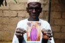 Sani Garba, 55, holds the picture of his 14-year-old daughter-in-law Wasila Tasi'u on August 10, 2014 inside her abandoned matrimonial home in the village of Unguwar Yansoro