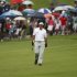 Mickelson of U.S. walks down fairway with spectators carrying umbrella during the second round of the Barclays Singapore Open golf tournament in Sentosa