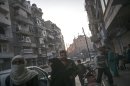In this Tuesday, Nov. 13, 2012 photo, Syrian residents walk on a main road in the Tarik Al-Bab neighborhood of Aleppo, Syria. (AP Photo/Narciso Contreras)