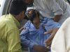 People carry a person injured by bombing at a mosque in Ghundi, in the Pakistani tribal area of Khyber on Friday, Aug 19, 2011. A bomb exploded in a mosque in a Pakistani tribal region as hundreds were gathered for prayers Friday, killing at least 40 people and wounding 85 others in the first major attack in the country during the Muslim holy month of Ramadan.(AP Photo/Qazi Rauf
