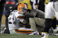 En esta foto del 8 de diciembre del 2011, el cuerpo médico de los Browns de Cleveland atiende al quarterback Colt McCoy, tras ser golpeado por el linebacker de los Steelers de Pittsburgh, James Harrison (AP Foto/Gene J. Puskar, archivo)