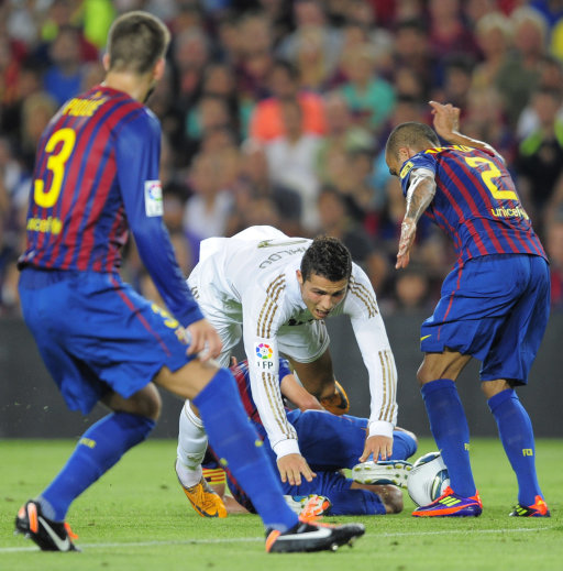 Real Madrid's Cristiano Ronaldo from Portugal, center, duels for the ball against FC Barcelona's Daniel Alves, from Brazil, right, during his Super Cup final second leg soccer match at the Camp Nou Stadium in Barcelona, Spain, Wednesday, Aug. 17, 2011. (AP Photo/Manu Fernandez)