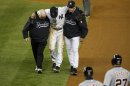 New York Yankees shortstop Jeter is carried off the field by trainer Donohue and manager Girardi after injuring himself while playing against the Detroit Tigers during the 12th inning of Game 1 of their MLB ALCS playoff baseball series in New York