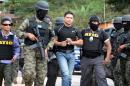 Members of the Honduran Military Police and of the Technical Agency of Criminal Investigation capture former National Police captain Alvaro Ernesto Garcia Calderon (C) in Valle de Angeles municipality, near Tegucigalpa on February 23, 2016