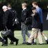 NFL quarterback Peyton Manning, second from right at rear, walks across a football practice field with Denver Broncos executive John Elway, fourth from left, near Wallace Wade Stadium, Friday, March 16, 2012, at Duke University in Durham, N.C. Elway and coach John Fox watched the star quarterback throw at Duke's athletic fields. (AP Photo/The News & Observer, Travis Long)
