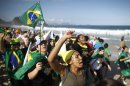 Pilgrims carrying a Brazilian flag sing on Copacabana beach in Rio de Janeiro, Brazil, Saturday, July 27, 2013. Pope Francis will preside over an evening vigil service on Copacabana beach that is expected to draw more than 1 million young people. (AP Photo/Victor R. Caivano)