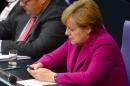 German Chancellor Angela Merkel uses her mobile phone during a session of the Bundestag Lower House of parliament in Berlin, June 4, 2014
