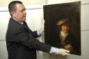 Policeman Colonel Stephane Gauffeny of the Central Office for the Fight against Trafficking of Cultural Property police division, presents to the press the Rembrandt's painting "Child with a Soap Bubble", stolen in 1999 from the municipal museum of Draguignan, southeastern France, Thursday, March 20, 2014, in Nice, southeastern France. The Rembrandt painting worth millions has been recovered in Nice, and two people found in possession of the Dutch master's painting have been arrested, a source close to the investigation said on March 19, 2014. (AP Photo/str)
