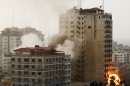 Smoke and fire are seen from an explosion by a high rise housing media organizations in Gaza City, Monday, Nov. 19, 2012. It's the Israel's military second strike on the building in two days. The Hamas TV station, Al Aqsa, is located on the top floor. (AP Photo/Hatem Moussa)