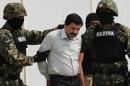 Joaquin "Shorty" Guzman (C) is escorted by soldiers during a presentation at the Navy's airstrip in Mexico City