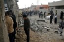 Iraqis look at the site of a blast targeting members of the Shabak community north of Baghdad on January 16, 2012