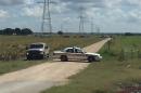 This handout photograph obtained courtesy of KXAN TV shows a police vehicle blocking a road where a hot air balloon crashed near Lockhart, Texas, July 30, 2016