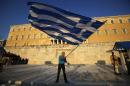 A pro-Euro demonstrator waves a Greek flag in front of the Greek Parliament as riot police, left, block an entrance of a building during a rally at Syntagma square in Athens, Thursday, July 9, 2015. Greece's government is racing to finalize a plan of reforms for its third bailout, hoping this time the proposal will meet with approval from its European partners and stave off a potentially catastrophic exit from Europe's joint currency, the euro, within days. (AP Photo/Petros Karadjias)