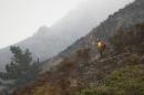 A firefighter stands on steep terrain while fire crews create fire breaks at Garrapata State Park during the Soberanes Fire north of Big Sur, California