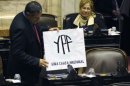 Un diputado argentino muestra una pancarta que dice "YPF. Una causa nacional"