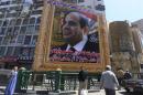 People stand under a huge banner of Egypt's former army chief Abdel Fattah al-Sisi in downtown Cairo