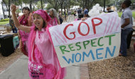 Medea Benjamin of Washington, D.C. displays her sign during a Code Pink protest before Republican National Convention, Sunday, Aug. 26, 2012, in Tampa, Fla. (AP Photo/Dave Martin)
